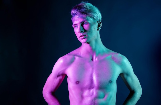 Foto di ragazzo bello pompato con torsi nudi Ragazzo sportivo corpo maschile attraente Riprese in studio con filtri colorati