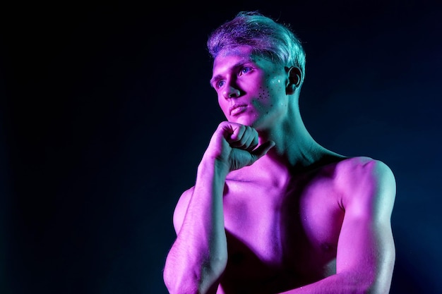 Foto di ragazzo bello pompato con torsi nudi Ragazzo sportivo corpo maschile attraente Riprese in studio con filtri colorati