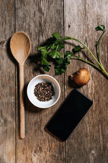 Foto di riserva di composizione degli alimenti naturale nella vista sopraelevata con lo smartphone, sulla tavola di legno naturale.