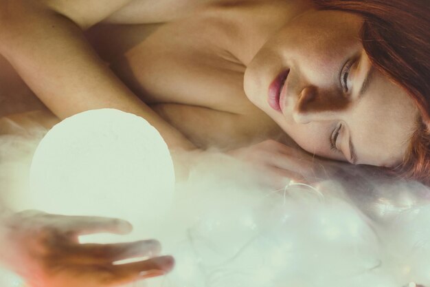 Foto di ritratto di una donna tranquilla in possesso di una sfera luminosa