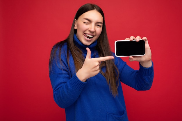 Foto di sexy bella giovane donna sorridente di bell'aspetto che indossa abiti casual ed eleganti in piedi