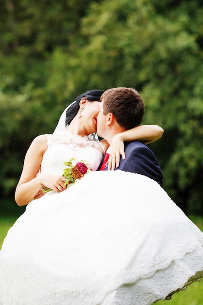 Foto di sposi novelli all'aperto. Bella giovane sposa e sposo innamorati.