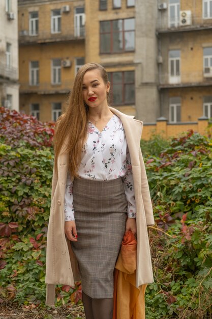 Foto di strada di giovane bella donna che indossa abiti classici alla moda. Modello guardando in basso. Concetto di moda femminile.