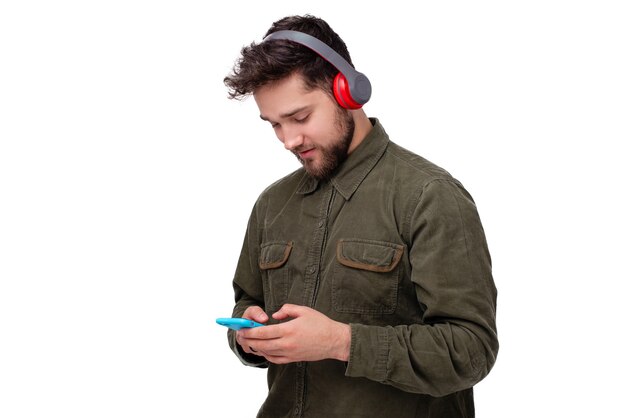 Foto di un bel giovane che usa il cellulare e ascolta musica con le cuffie