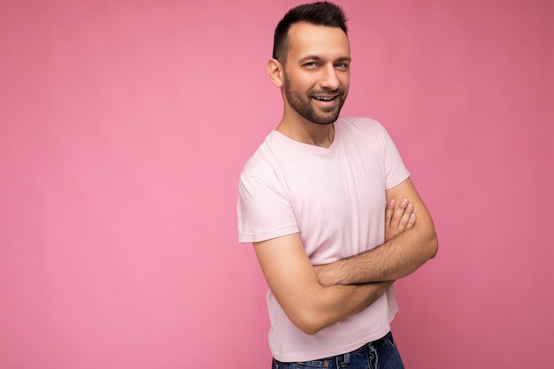 Foto di un bell'uomo brunet positivo fiducioso con una maglietta rosa casual isolata su sfondo rosa con spazio copia per il testo