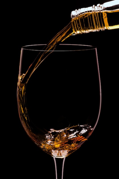 Foto di un bicchiere di whisky e ghiaccio su sfondo nero
