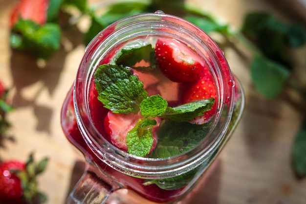 Foto di un cocktail alla fragola con menta verde fresca. Limonata estiva fredda con fragole