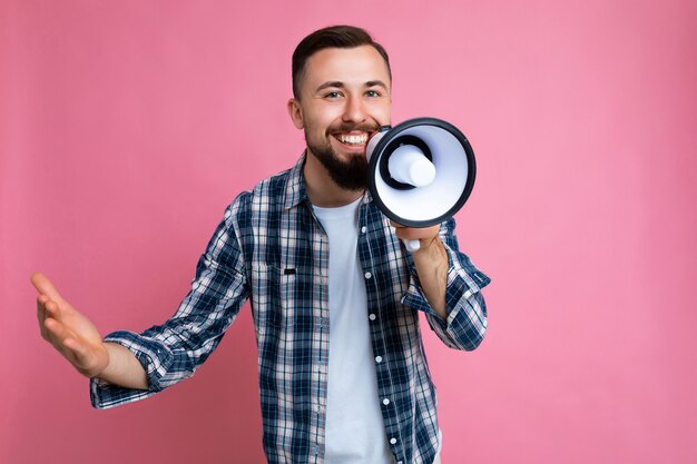 Foto di un giovane bell'uomo sorridente felice e sorridente con la barba con emozioni sincere che indossano