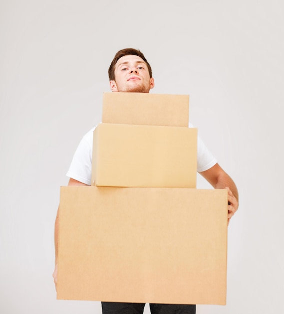 foto di un giovane che trasporta scatole di cartone