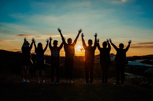 Foto di un gruppo di persone a cui piace guardare il tramonto all'alba