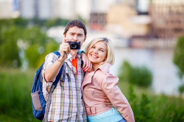 Foto di un uomo con una donna che scatta una foto nel parco in estate