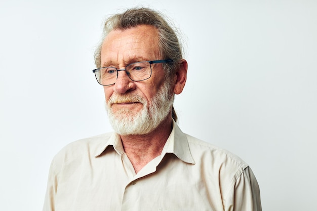Foto di un vecchio pensionato con la barba grigia in camicia e occhiali inalterati