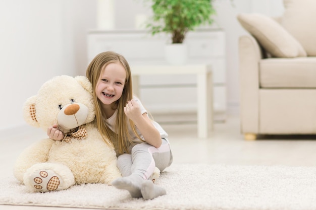 Foto di una bambina che la mostra mentre gioca con il suo orsacchiotto