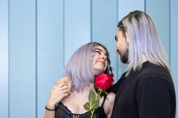 Foto di una coppia che condivide un momento romantico con in mano una rosa