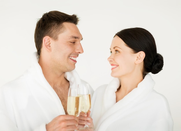 foto di una coppia nel salone della spa in accappatoi bianchi con champagne