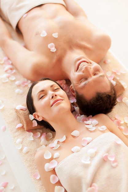 foto di una coppia nel salone della spa sdraiata sui lettini per massaggi