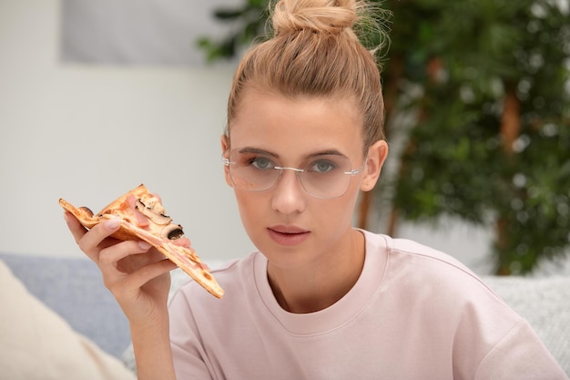 Foto di una donna attraente che mangia una fetta di pizza vestita con abiti alla moda bella ragazza snacki
