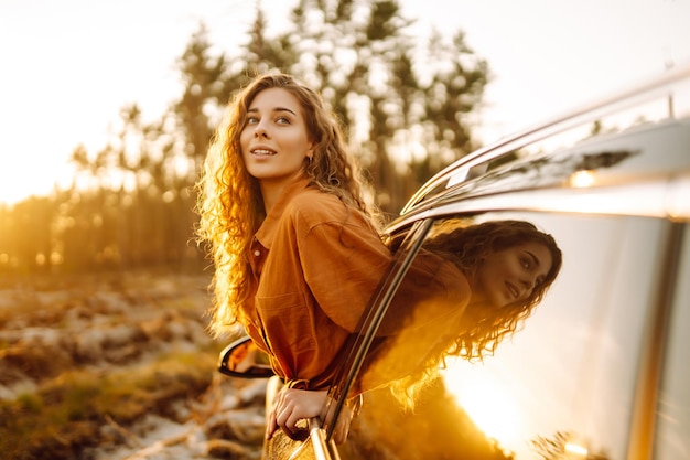 Foto di una donna attraente che si appoggia dal finestrino dell'auto mentre guida