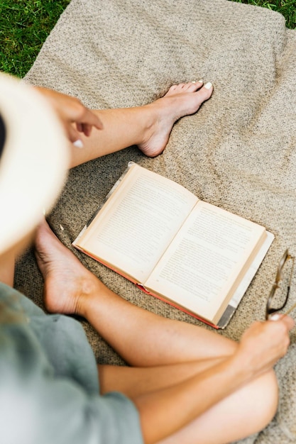 Foto di una donna che legge un libro su una coperta