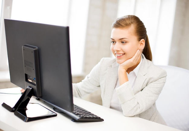 foto di una donna d'affari sorridente con un computer in ufficio