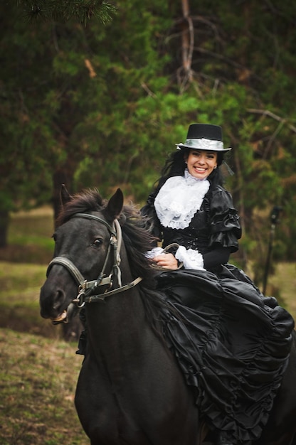 Foto di una donna in un bellissimo costume teatrale, a cavallo nella natura