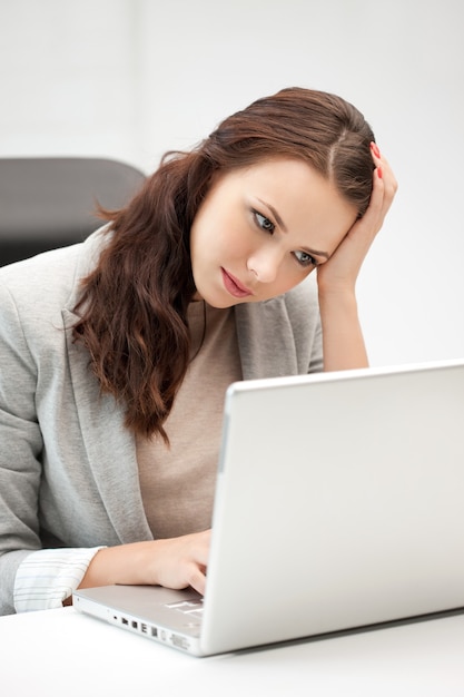foto di una donna pensierosa con un computer portatile