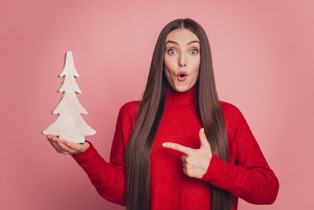 Foto di una donna scioccata che dirige la vendita natalizia fatta a mano di un albero di abete in legno