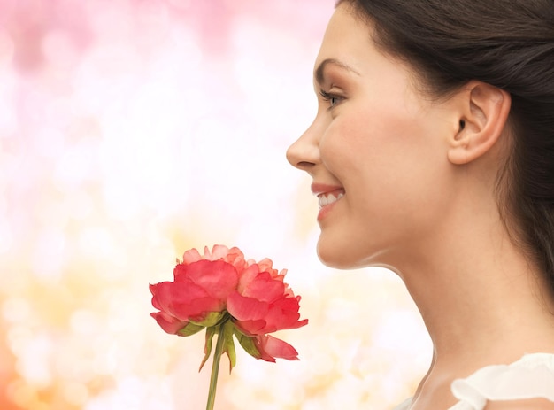 foto di una donna sorridente che odora di fiori