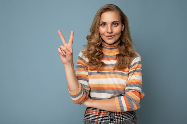 Foto di una giovane bella donna positiva e sorridente con emozioni sincere che indossa abiti eleganti