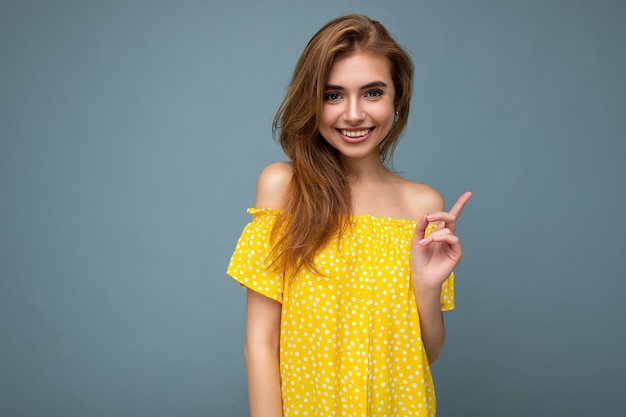 Foto di una giovane bella donna positiva e sorridente con emozioni sincere che indossa abiti eleganti