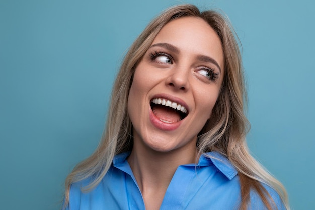 Foto di una giovane donna adorabile con un ampio sorriso su uno sfondo blu