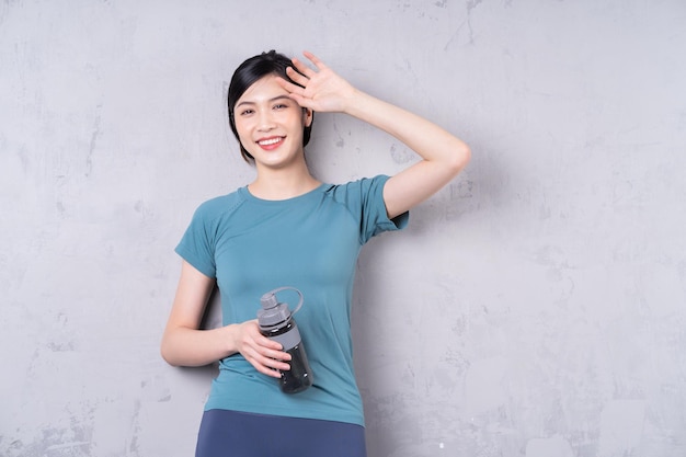 Foto di una giovane donna asiatica che tiene una bottiglia d'acqua