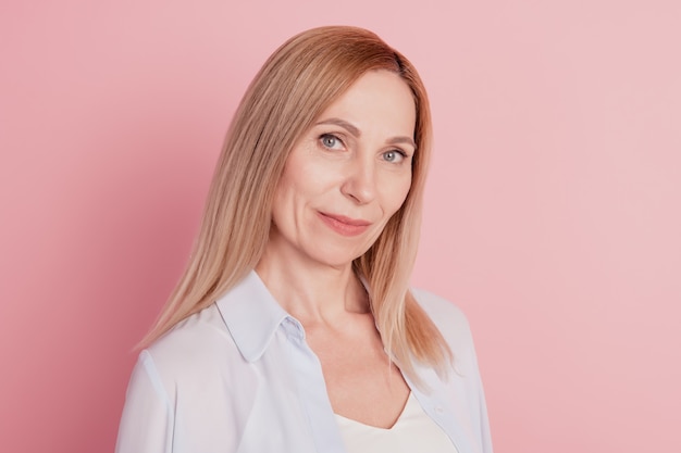 Foto di una giovane donna attraente sicura di sé che indossa una camicia isolata su uno sfondo di colore rosa pastello