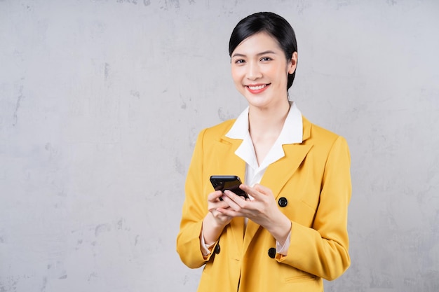 Foto di una giovane donna di affari asiatica che tiene il telefono