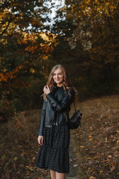 foto di una ragazza felice su uno sfondo di bosco in autunno