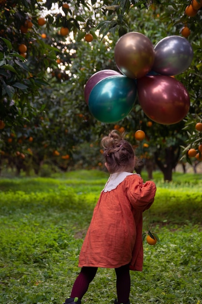 Foto di una ragazza in giardino tra alberi da frutto