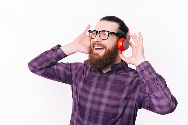 Foto di uomo allegro felice in musica d'ascolto informale in cuffia e occhiali da vista