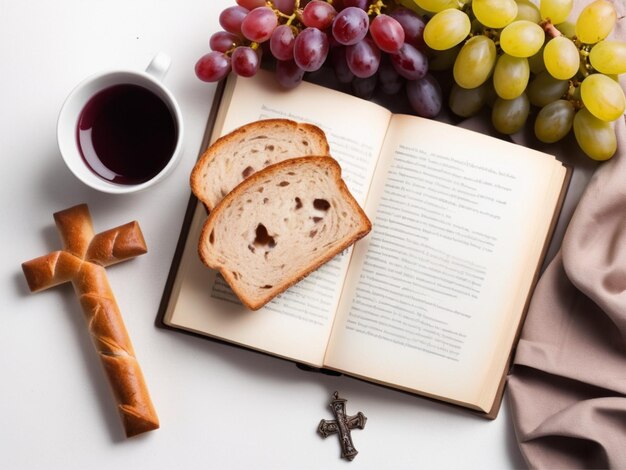 Foto di uva in tazza di pane e croce su libro su sfondo bianco vista superiore