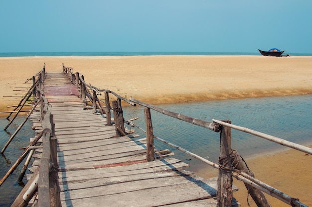 Foto di viaggio creativa con spiaggia di mare cielo blu e strada di assi di legno che porta lontano