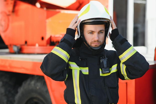 Foto di vigile del fuoco con maschera antigas e casco vicino all'autopompa