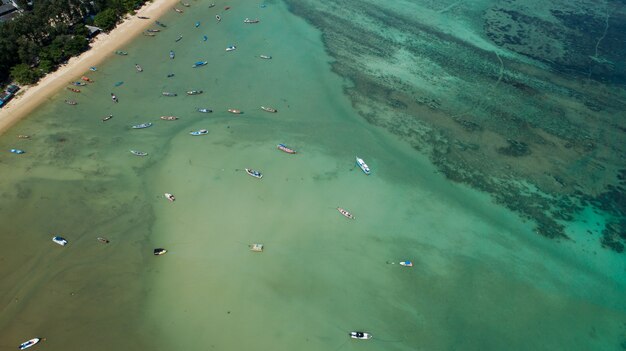 Foto di vista dall'alto del drone aereo Dall'alto verso il basso del mare tropicale con barche da pesca a coda lunga a phuket, Thailandia Incredibile superficie del mare tropicale.