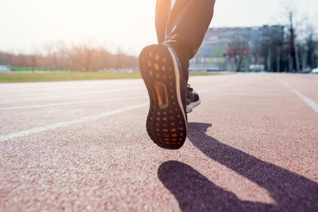 Foto dietro le gambe dell'atleta che attraversa lo stadio