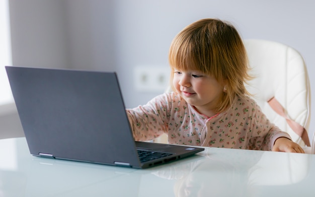 Foto divertente - bambino con laptop sul lavoro a distanza, apprendimento