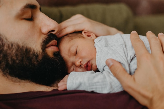 Foto domestiche di un neonato tra le braccia del padre Effetto rumore di messa a fuoco selettiva