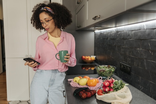 Foto donna guardare il telefono in cucina