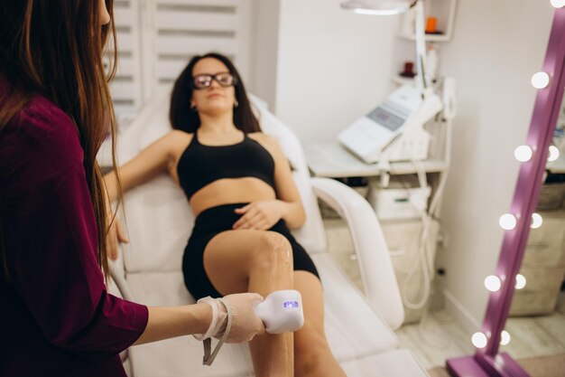 Foto epilazione primo piano della procedura di depilazione sulle gambe in salone