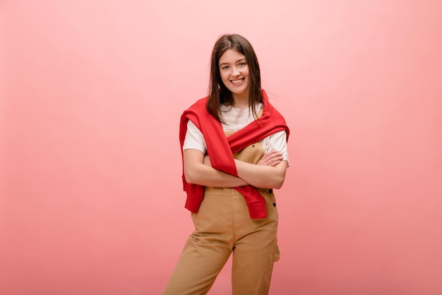 Foto giovane donna caucasica vestita con abiti casual incrocia le braccia su uno spazio vuoto su sfondo rosa Concetto di stile di vita delle emozioni sincere delle persone