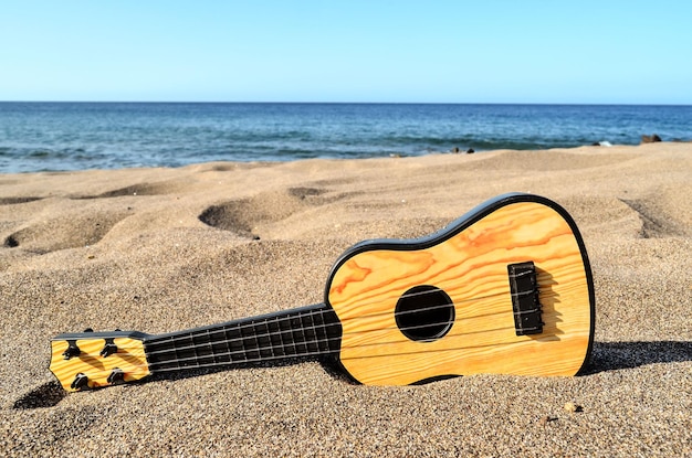 Foto Immagine di una chitarra sulla spiaggia di sabbia