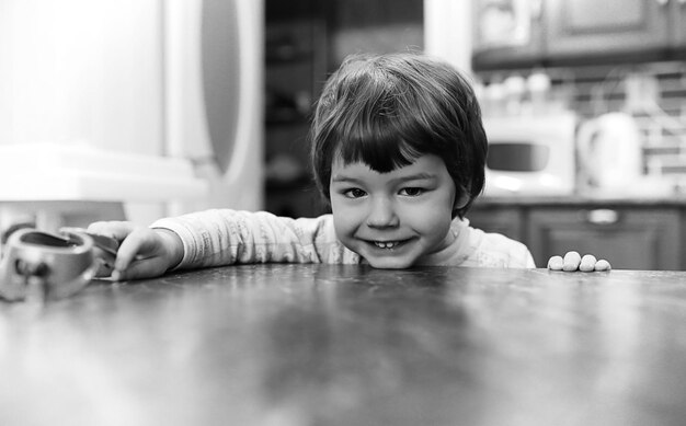 Foto in bianco e nero di un bambino che sorride e si diverte a sfondo bianco