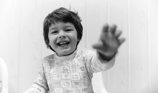 Foto in bianco e nero di un bambino che sorride e si diverte a sfondo bianco